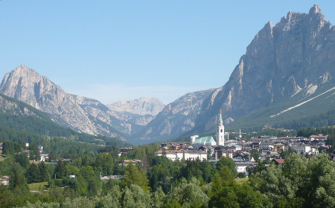 View of Cortina d'Ampezzo in the valley, surrounded by high mountain peaks at daytime