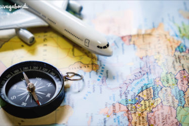 miniature tourist on compass over map with plastic toy airplane,abstract background to travel concept.