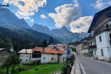 View of some mountain houses with murals in Cibiana di Cadore, Dolomites, Italy, and mountain view in the background