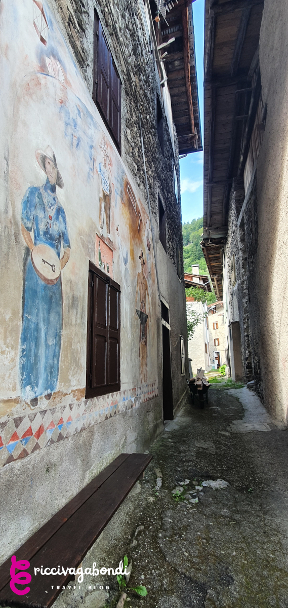 View of narrow streets with murals on the walls in Cibiana di Cadore, Dolomites, Italy