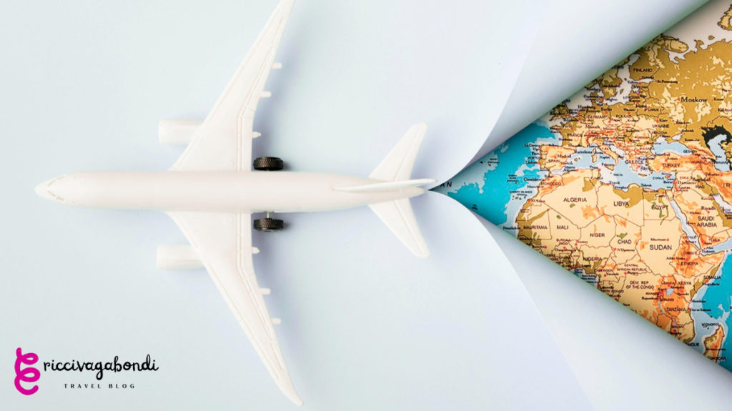 View of a toy white plane and a travel world map in the background