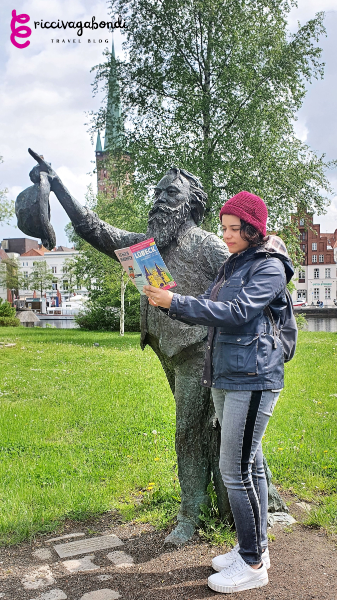 View of riccivagabondi asking a statue for information in Lübeck, Germany