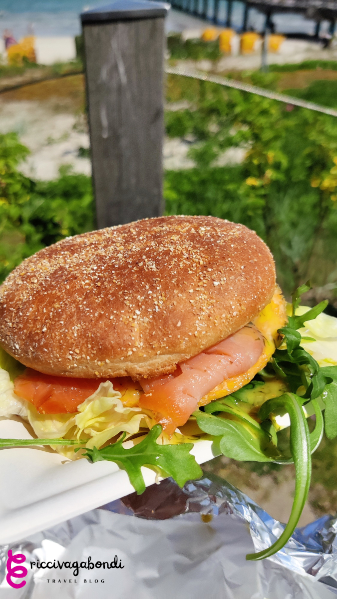 View of a fish bun with salmon, cheese and rocket salad